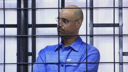 Saif al-Islam Gaddafi, son of late Libyan leader Muammar Gaddafi, attends a hearing behind bars in a courtroom in Zintan May 15, 2014. REUTERS/Stringer (LIBYA - Tags: POLITICS CIVIL UNREST) - RTR3PCA8