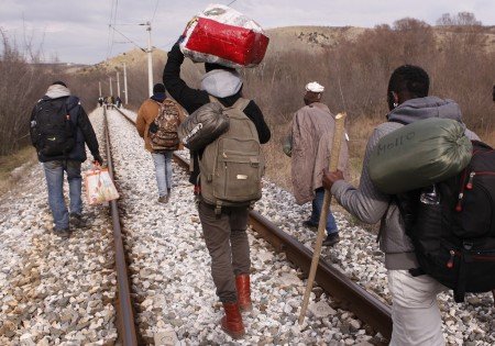 Emigrantes africanos caminan junto a las vías de un tren durante una travesía a pie de 250 kilómetros por la frontera entre Grecia y Macedonia, que es el tramo más duro de una nueva ruta hacia la Unión Europea por los Balcanes. Foto del 28 de febrero del 2015 tomada cerca de Evzonoi, Grecia. (AP Photo/Dalton Bennett)