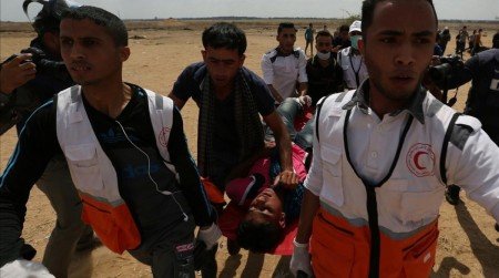 A wounded Palestinian is evacuated during a protest against U S embassy move to Jerusalem and ahead of the 70th anniversary of Nakba at the Israel-Gaza border in the southern Gaza Strip May 14 2018 REUTERS Ibraheem Abu Mustafa